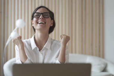 Heyecanlı Latin kadın serbest çalışan yumruklarını neşeyle sıktı ve sevinçle kafasını kaldırdı. Sanki 