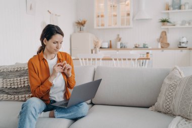 Dizüstü bilgisayar kullanan genç bir kadın evdeki rahat koltukta oturuyor. Güzel bir kadın sosyal ağlarda sohbet ediyor, internetten alışveriş yapıyor, kanepede film veya dizi izliyor..