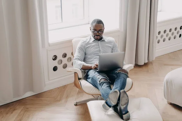 Skupiony Afrykański Biznesmen Pracuje Online Laptopie Siedzi Fotelu Domu Nowoczesny — Zdjęcie stockowe