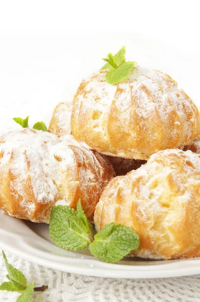 Profiteroles with cream and powdered sugar — Stock Photo, Image