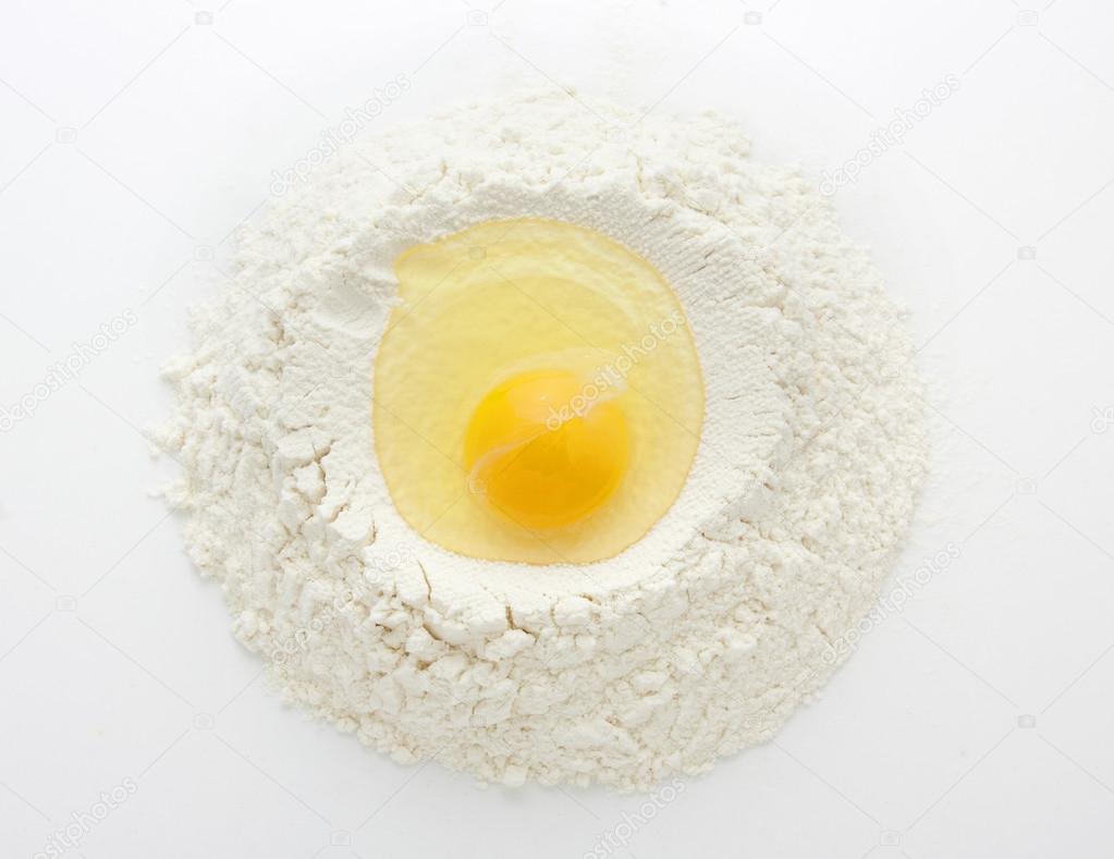 Heap of wheat flour with raw egg