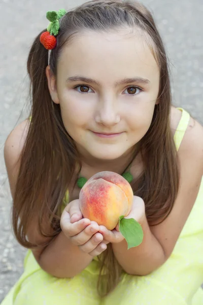 Portret dziewczynka gospodarstwa brzoskwinia — Zdjęcie stockowe