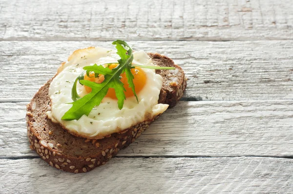 Sandwich with fried egg and arugula — Stock Photo, Image
