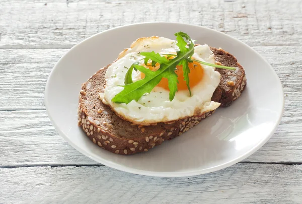 Sandwich with fried egg and arugula — Stock Photo, Image