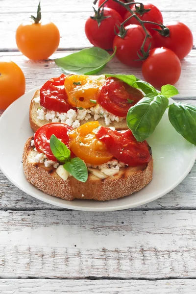 Тосты с мягким сыром и помидорами черри — стоковое фото