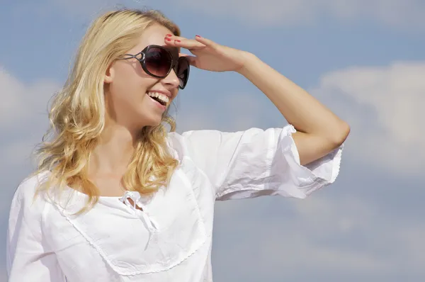 Beautiful girl in sunglasses on background blue sky Royalty Free Stock Photos