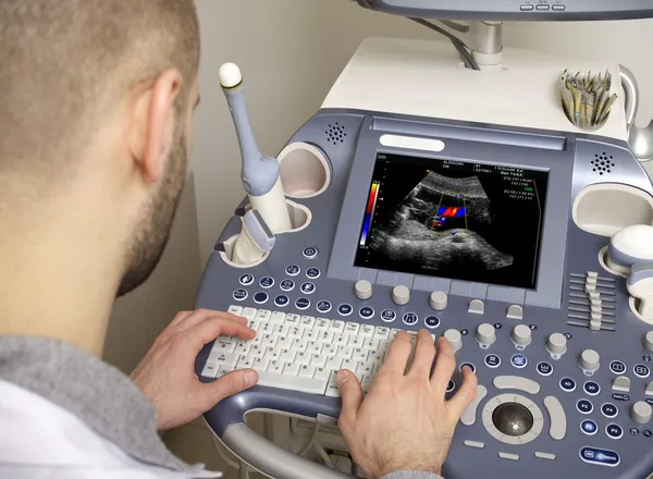 Portrait of young male technician operating ultrasound machine — Stock Photo, Image