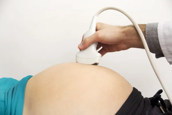 Pregnant woman getting ultrasound from doctor — Stock Photo, Image