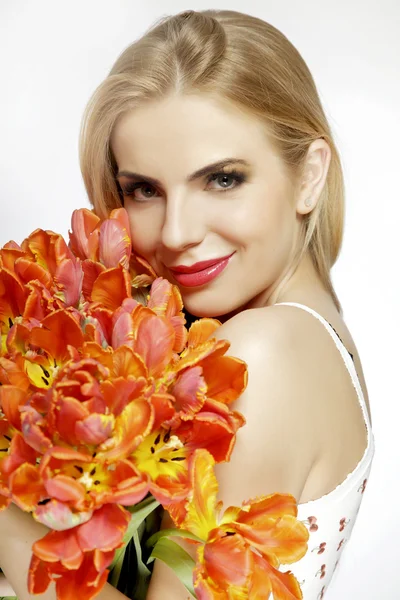 Krásná blondýnka s kyticí tulipánů izolovaných na w — Stock fotografie