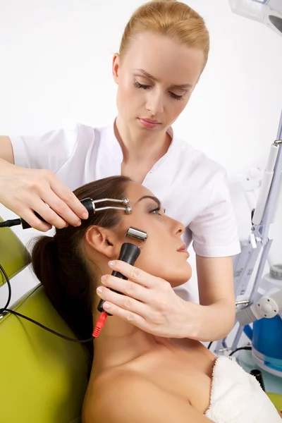 Frau bei einer stimulierenden Gesichtsbehandlung durch einen Therapeuten — Stockfoto