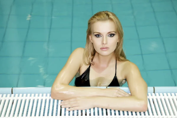 Mulher bonita em pé em uma piscina — Fotografia de Stock