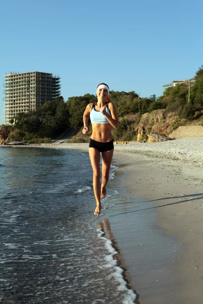 Beautiful young sport woman running on beach. — Stock Photo, Image