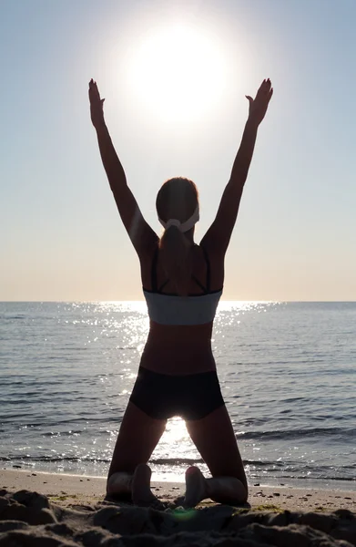 Ung kvinna i en meditation på stranden — Stockfoto