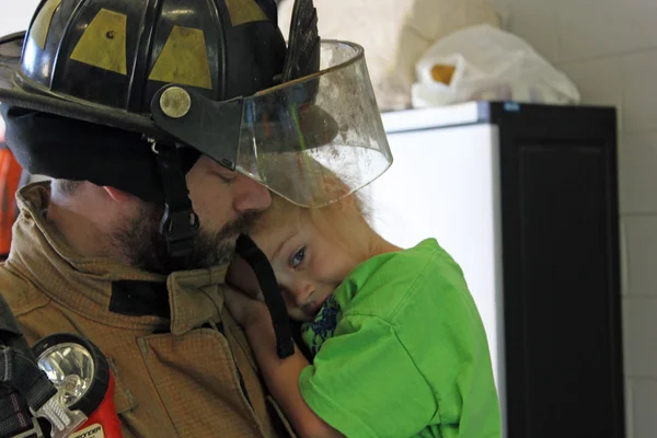 Feuerwehrmann hält seine Tochter fest — Stockfoto