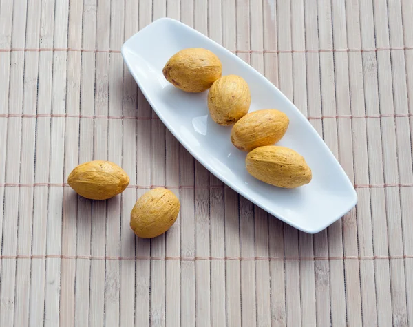 Dish of nuts on a bamboo napkin — Stock Photo, Image