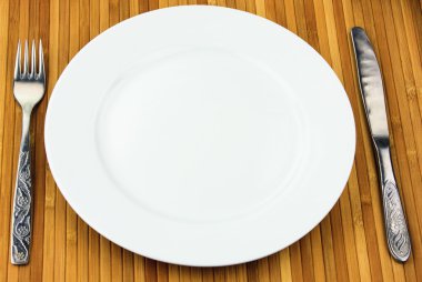 Beyaz tabak, bıçak ve çatal, bambu peçete