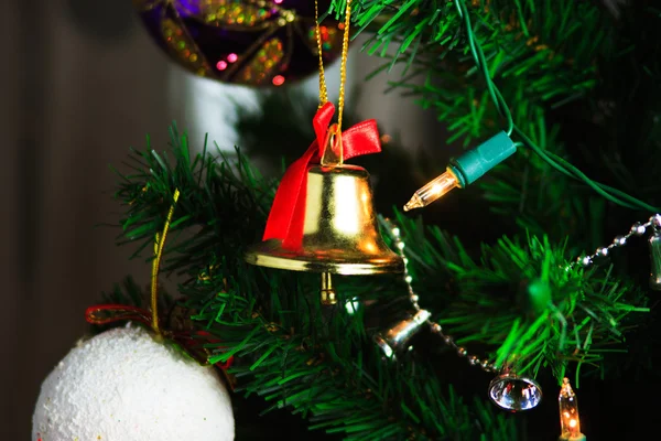 Рождественский колокол висит на рождественской елке — стоковое фото