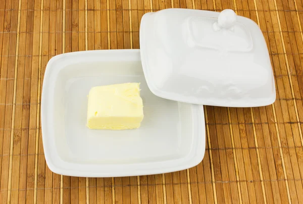 Oval dish with butter on bamboo napkin — Stock Photo, Image