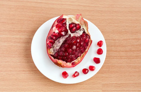 Der geschnittene Granatapfel und die Körner auf einem Teller — Stockfoto