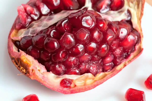 The cut pomegranate and grains on a plate — Stock Photo, Image