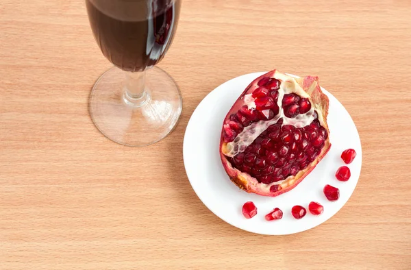 Cálice de vinho e uma romã na mesa — Fotografia de Stock