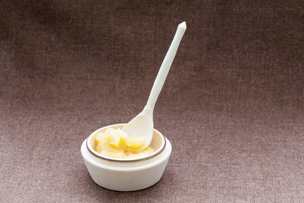 Pot of honey and wooden dipper on a sackcloth — Stock Photo, Image