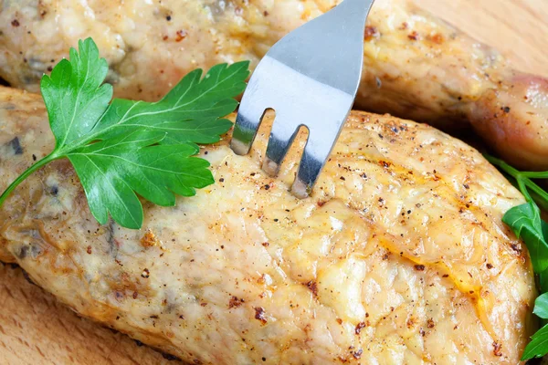 Pierce the chicken with a fork on a cutting board — Stock Photo, Image