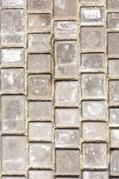 Fragmento de fundo do caminho. Caminho feito de pequenos tijolos cinzentos . — Fotografia de Stock