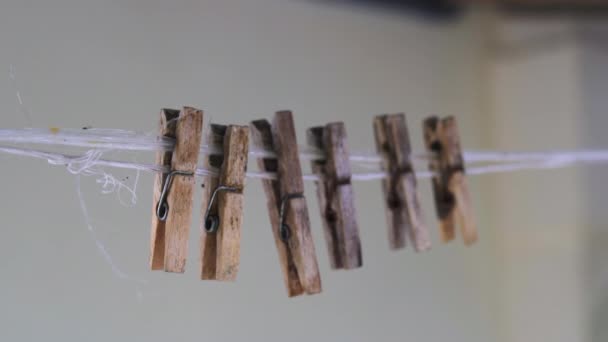 Sześć starych drewnianych szpilek wisi na linie. — Wideo stockowe