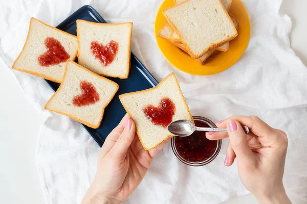 少女は心がジャムでできているトーストを作る ベッドの中で驚きの朝食コンセプト バレンタインデーのロマンス — ストック写真