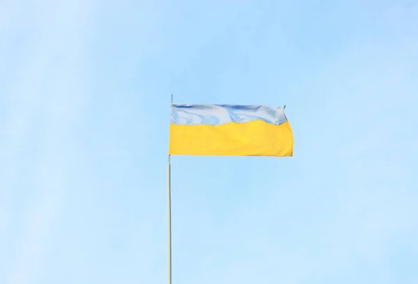 Ukrainian blue and yellow flag in the wind. Background of blue sky and light white clouds. The national flag of Ukraine — Stock Photo, Image