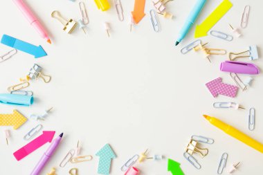 Kırtasiye malzemeleri, okul malzemeleri beyaz bir masada, parlak pastel renklerde. Ofis ayarlandı, bir yazı için yer
