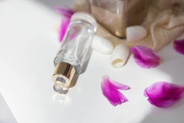 Doğal kozmetik ürünleri. Şakayık yapraklarının arka planındaki yüz için güzel bir sıvı kavanozu.