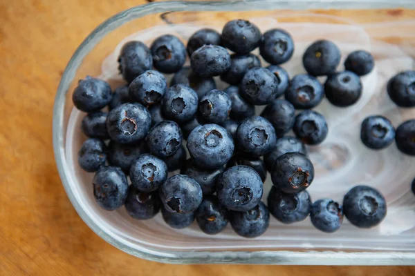 Verse Bosbessen Een Transparante Plaat Een Houten Tafel Bovenaanzicht Natuurlijke — Stockfoto