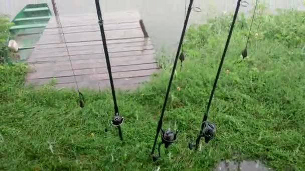 有饵的钓竿站在湖边的雨中 河里的钓竿和雨天 — 图库视频影像