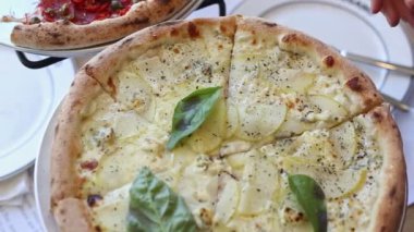 The girl hand tears off a slice of hot pizza. Food delivery home concept. Woman cook takes a slice of juicy cheese pizza - close up.