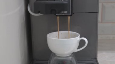 İtalyan espresso makinesi taze kahve yapıyor. Otomatik makineden dökülen latte akımının görüntüsü. Sabah kahvaltıda taze öğütülmüş sade kahve içmek.