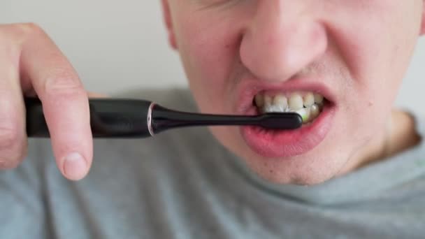 Junger Mann Mit Elektrischer Zahnbürste Die Zähne Putzt Und Heimischen — Stockvideo