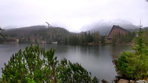 ブラチスラバ スロバキア 2020年5月21日 山の湖Strbske Plesoの春の風景 冬のスポーツのための石 霧の中で高タトラの雪に覆われたピーク ダイビングボードやスポーツ複合体 — ストック動画