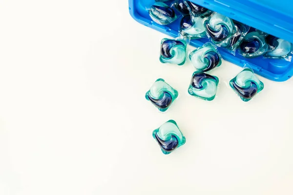 蓝色和蓝色的洗涤胶囊分散在白色的背景上 洗衣服的过程 洗液凝胶 — 图库照片
