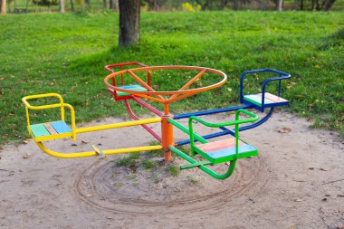 Yeşilliklerle çevrili parlak bir oyun alanı, bir sürü farklı çocuk salıncakları, dinlenmek için güzel ve rahat bir park.