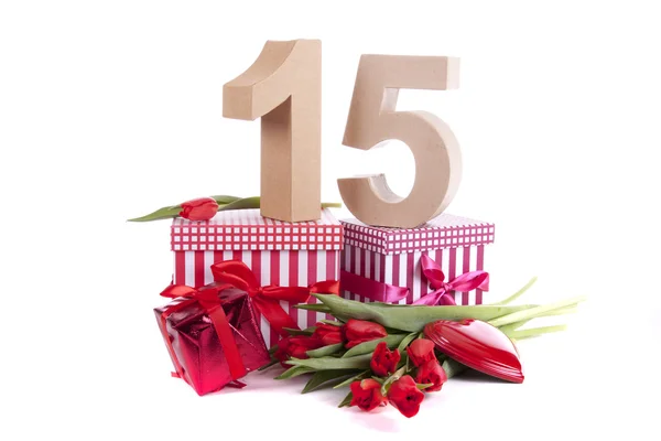 Age in figures in a party mood on a bed of red tulips — Stock Photo, Image