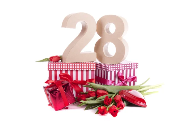 Věk v číslech v party náladě na lůžku z červené tulipány — Stock fotografie