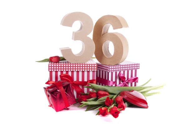 Idade em números em um humor de festa em uma cama de tulipas vermelhas — Fotografia de Stock