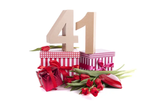 Ålder i siffror på partyhumör på en bädd av Röda tulpaner — Stockfoto