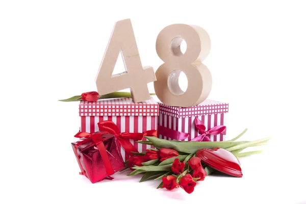 Age in figures in a party mood on a bed of red tulips — Stock Photo, Image