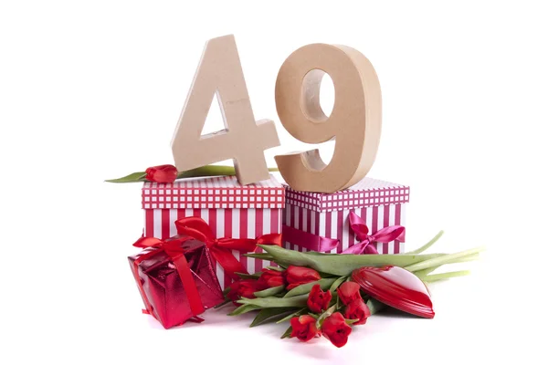 Âge en chiffres dans une humeur de fête sur un lit de tulipes rouges — Photo