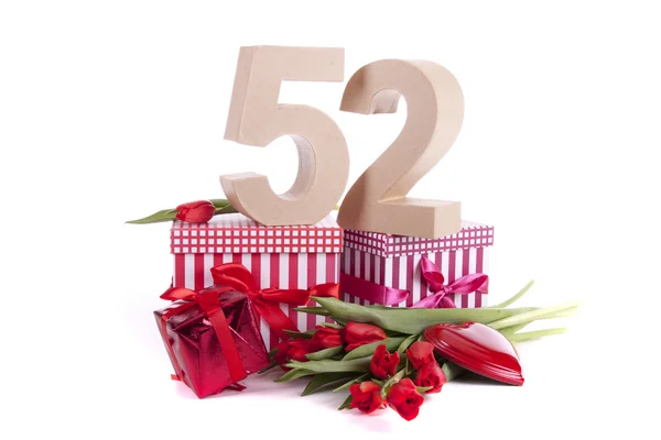 Leeftijd in cijfers in een feeststemming op een bedje van rode tulpen — Stockfoto