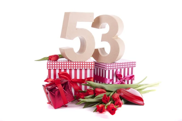 Leeftijd in cijfers in een feeststemming op een bedje van rode tulpen — Stockfoto