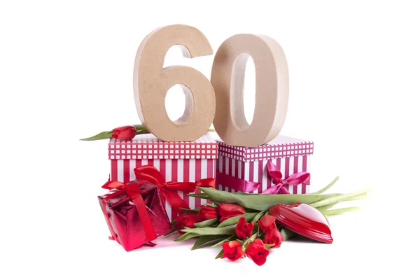 La edad en las figuras en el humor de fiesta sobre la cama de los tulipanes rojos — Foto de Stock